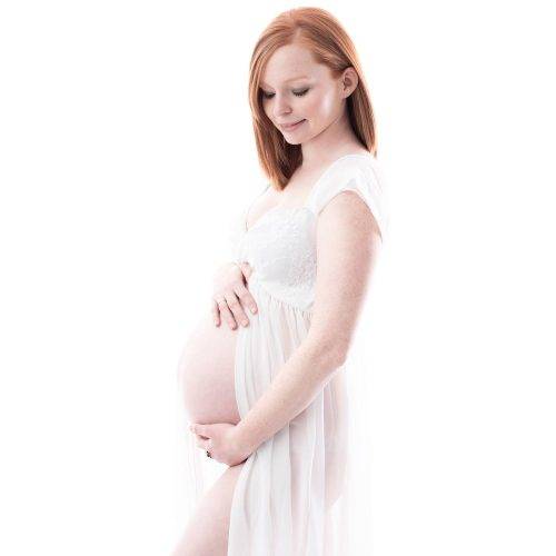 Zeitloses Schwangerschaftsfoto in weiß gehüllt fotografiert von Siebenschön Photography in der Nähe von Gütersloh