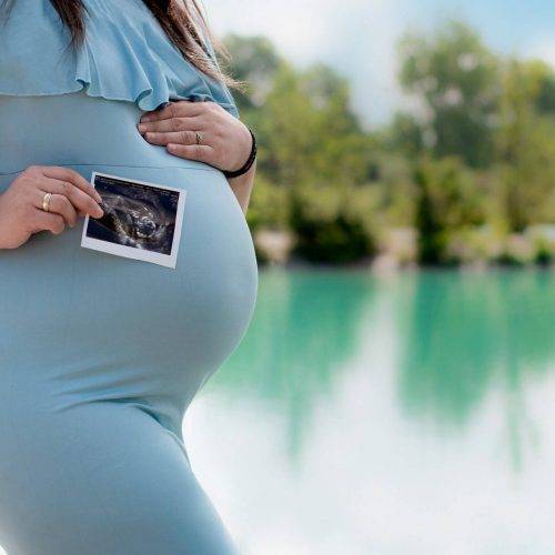 Babybauchfoto mit einem Ultraschallbild in freier Natur fotografiert von Siebenschön Photography in Sendenhorst